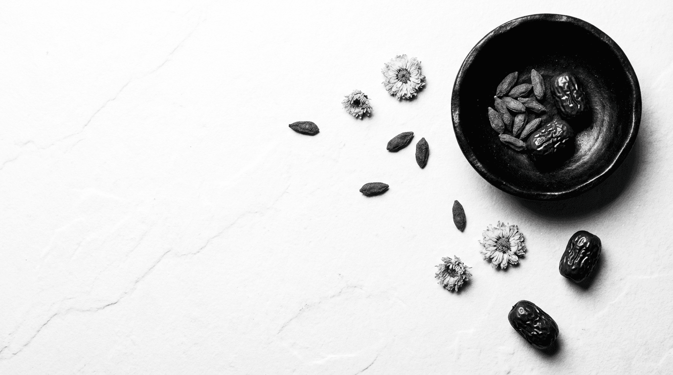 Black ceramic bowl with red dates, goji berries and dried chrysanthemum flowers